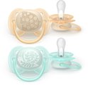 Twee Philips Avent ultra zachte fopspenen, één beige met bloemetjes, één mintgroen met slak. De achtergrond toont extra exemplaren.