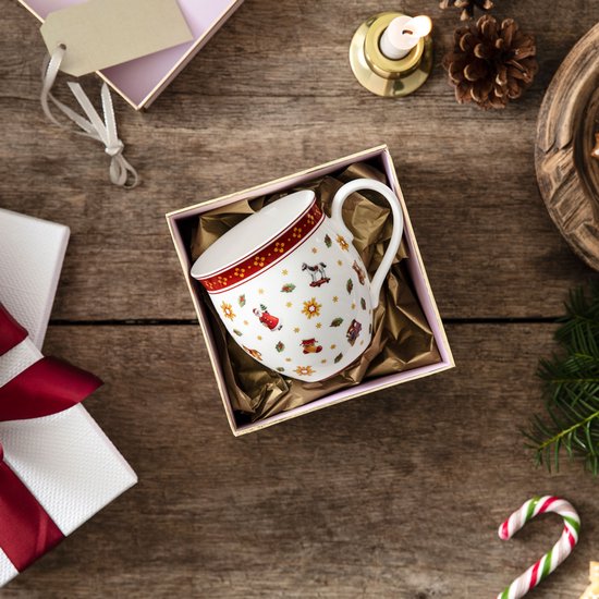 Mug blanc à motif de Noël, dans une boîte cadeau sur fond de bois.