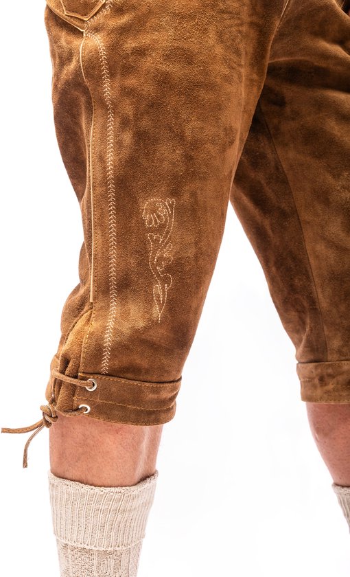 Korte, lichtbruine lederhosen met veterdetails aan de onderkant en geborduurde versieringen op het been.