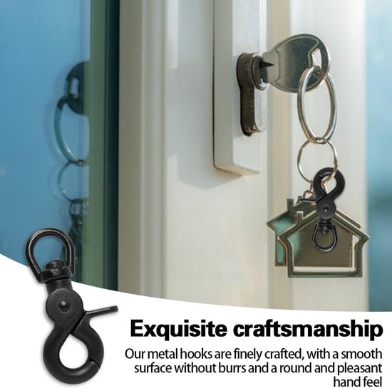 Een zwarte karabijnhaak met schaarclip en D-ring die aan een huissleutel is bevestigd, hangend bij een slot. Een andere zwarte karabijnhaak is aan de linkerkant te zien.