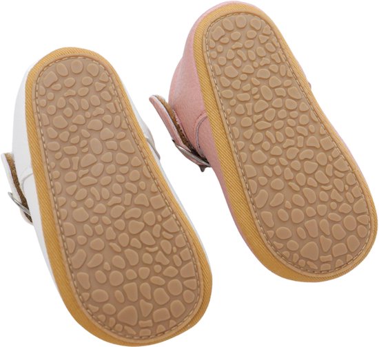 Onderkant van roze en witte babyschoentjes met antislipzool.