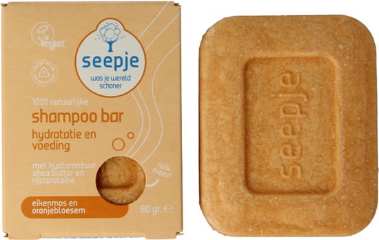 Kartonnen verpakking en Seepje shampoo bar naast elkaar. De bar is rechthoekig met afgeronde hoeken.