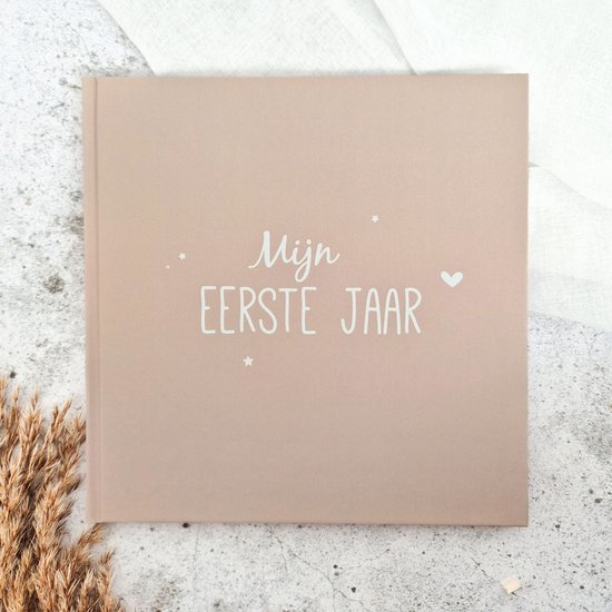 Zandkleurig babyboek met de tekst 'Mijn EERSTE JAAR' in witte letters.