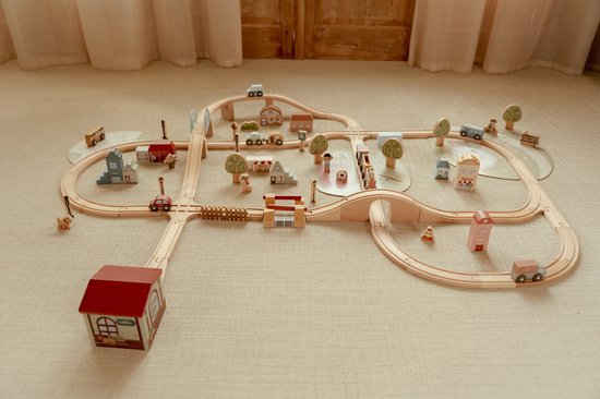 Houten treinbaan met vele accesoires zoals huisjes, auto's en een rode trein.