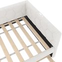 Close-up van de witte slaapbank met hexagonaal patroon, houten lattenbodem en stoffen bekleding.