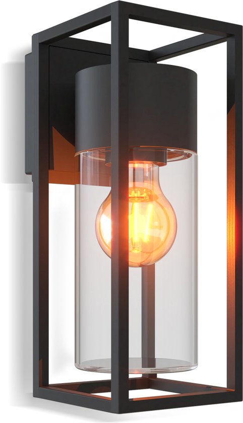 Zwarte, moderne buitenwandlamp met glazen cilinder en E27 fitting, die licht uitstraalt.
