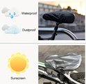 Zwarte hoes op een fietszadel, met icoon van regen en wolken. Zilverkleurige hoes op fietszadel, met zonicoon.
