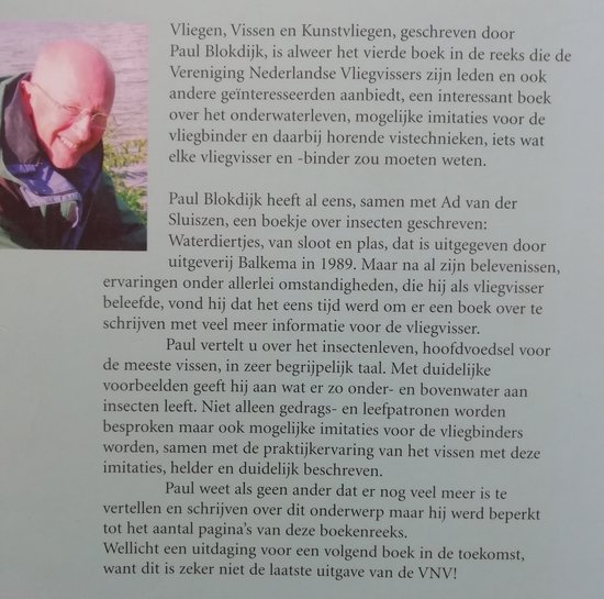 Foto van een man met een bril, lachend naar de camera.