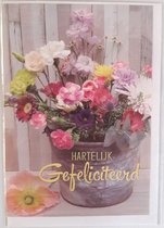Hartelijk gefeliciteerd! Een kleurrijke wenskaart met allerlei verschillende bloemen in mooie kleuren. Een leuke kaart om zo te geven of om bij een cadeau te voegen. Een dubbele wenskaart inclusief envelop en in folie verpakt.