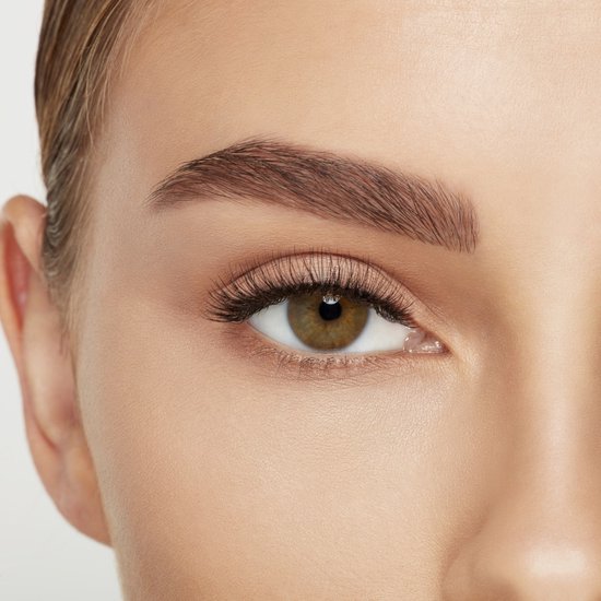 Open oog met bruine iris, natuurlijke wimpers en volle wenkbrauw.