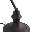 Détail de la base noire et ornementée d'une lampe de banquier.