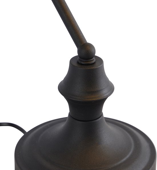 Détail de la base noire et ornementée d'une lampe de banquier.