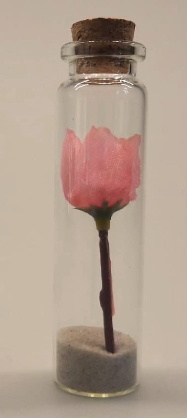 Dit lieve bloemetje wat voor altijd bewaard kan blijven. In een miniglaasje, circa 8 cm hoog. Een speciaal geschenk wat het hele jaar door gegeven kan worden. Een roze kunstbloemetje in een glazen flesje met op de bodem een laagje zand.