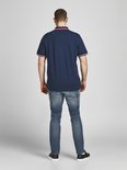 Achterkant man met donkerblauw poloshirt met rode/witte kraag- en mouwboorden.
