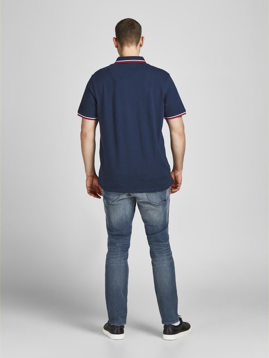 Achterkant man met donkerblauw poloshirt met rode/witte kraag- en mouwboorden.