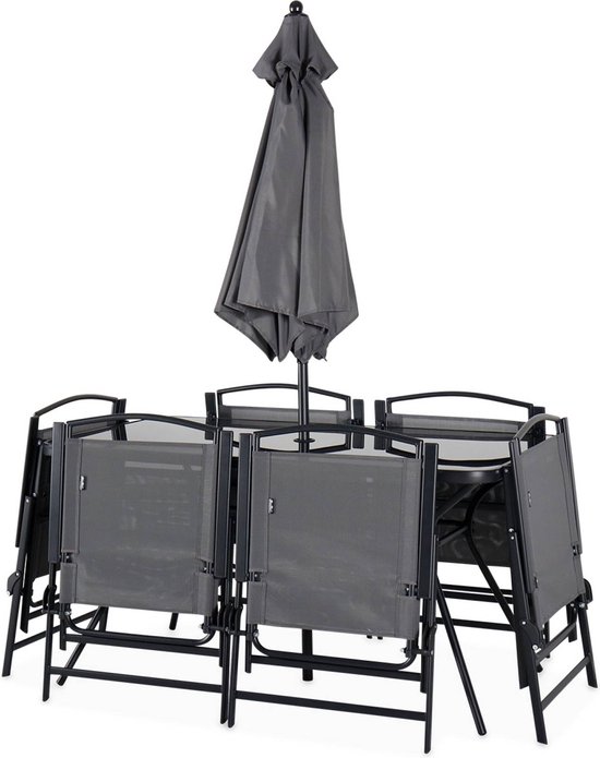 Grijze tuinset met gesloten parasol en opgevouwen stoelen.
