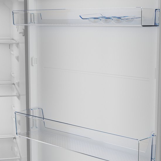 Binnenkant van een open Beko koelkast met glazen legplateaus en doorzichtige deurvakken.