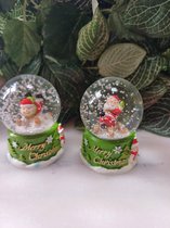 Set van 2 Sneeuwbollen kerst : sneeuwman en kerstman op slee op groene voet versierd met Kerstbomen en Merry Christmas