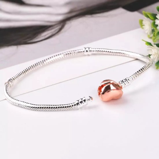 Verzilverde bedelarmband met een rose hartvormige sluiting, open.