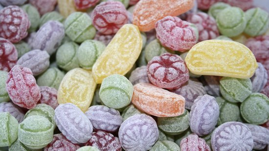 Gedetailleerde close-up van Felko zuurtjes in diverse kleuren en vormen, zoals rondjes, ovaal en vruchten.