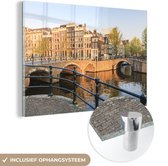 MuchoWow® Glasschilderij 120x80 cm - Schilderij acrylglas - Grachtenpanden en bruggen in Amsterdam - Foto op glas - Schilderijen