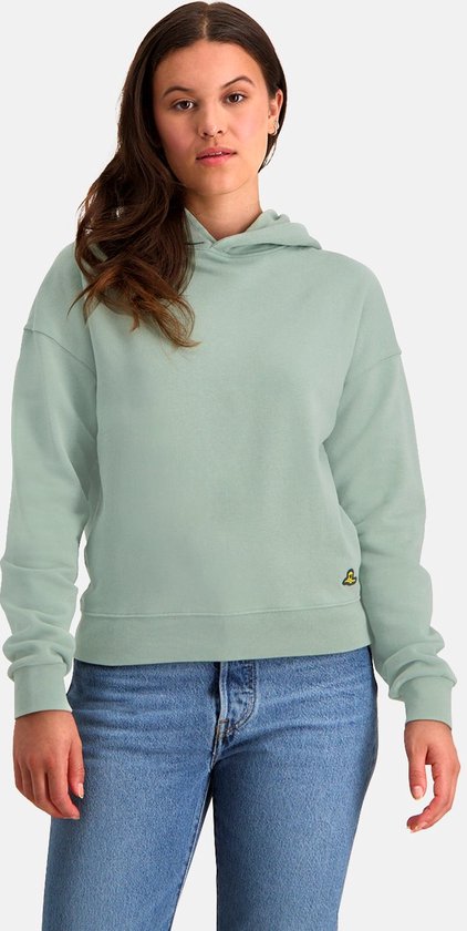 Model draagt een mintgroene NOMAD hoodie met jeans.