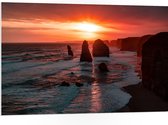 WallClassics - PVC Schuimplaat- Rotsen in de Zee met Zonsondergang - 105x70 cm Foto op PVC Schuimplaat