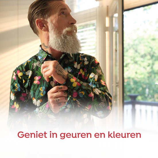 Man met baard en tatoeages, draagt een groen shirt met vlinderprint.