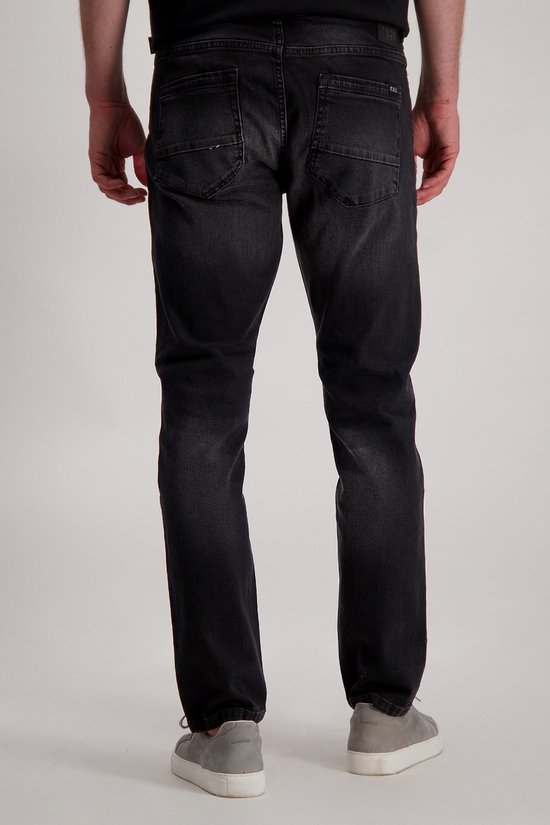 Achterkant van een donkergrijze jeans met lichte wassing, gedragen door model.
