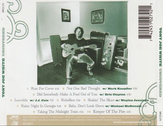 Tony Joe White met gitaar in een kamer, zittend op een stoel. Album 'Uncovered'.
