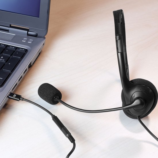 Adaptateur noir ACT USB-C vers 3.5mm connecté à un ordinateur portable, avec casque.