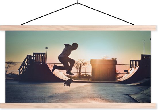 Posterhanger incl. Poster - Schoolplaat - Een jongen doet een stunt met zijn skateboard tijdens de zonsondergang - 150x75 cm - Blanke latten