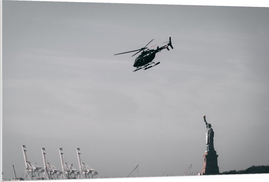 WallClassics - PVC Schuimplaat - Helikopter zwevend boven Vrijheidsbeeld in New York - 120x80 cm Foto op PVC Schuimplaat (Met Ophangsysteem)