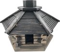 Houten vogelhuisje met blokhutmuren, donker dak en centrale schoorsteen.