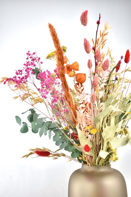 Close-up van een kleurrijk boeket droogbloemen met roze statice, oranje lampionnetjes en eucalyptus.