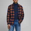 Man draagt donkerblauwe coltrui onder een geruite blouse met oranje en marineblauw