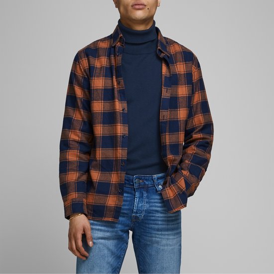 Man draagt donkerblauwe coltrui onder een geruite blouse met oranje en marineblauw