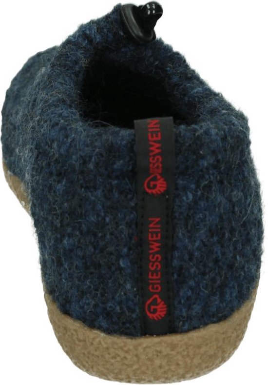 Donkerblauwe pantoffel met een textuur van wolmix en een beige zool. De achterkant heeft een rood-zwart label met het Giesswein logo.
