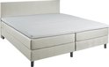 Luxe beige boxspring met gestreept matras en hoofdbord, in een slaapkamerinterieur.