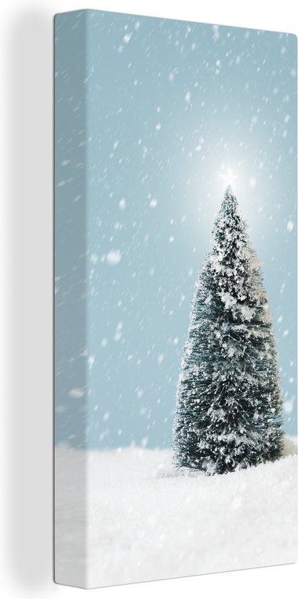 Canvas Schilderij Een kerstboom in een besneeuwd landschap en een blauwe hemel - 20x40 cm - Wanddecoratie