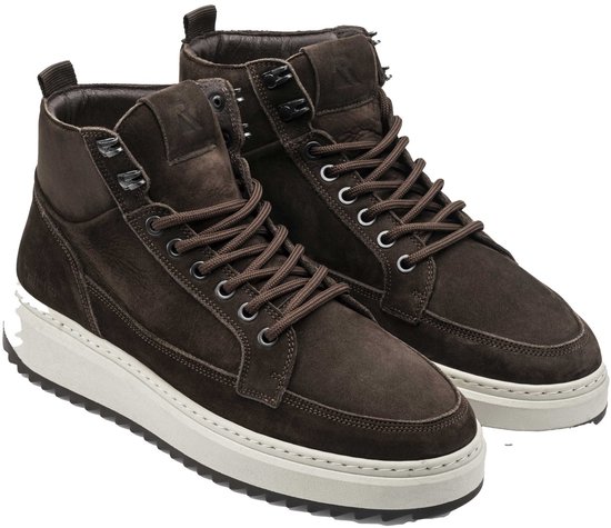 Bruine suède hoge sneakers met witte zolen, bruine veters en metalen veterringen.