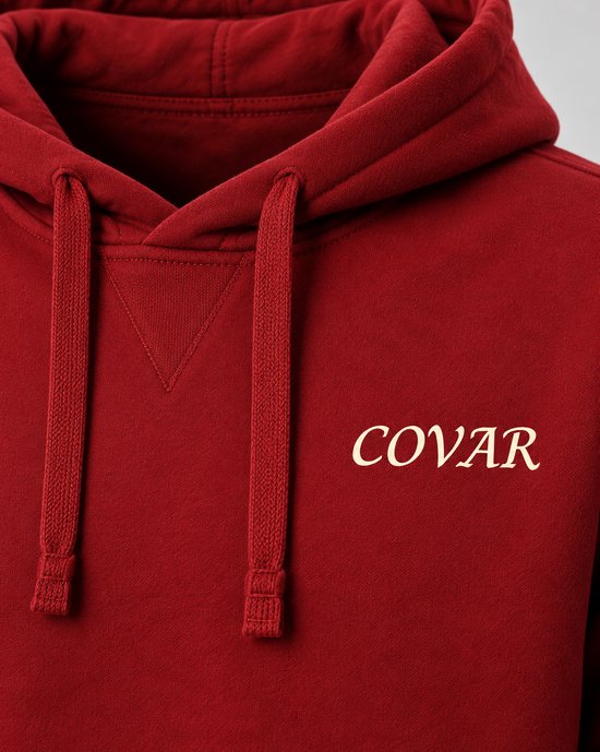 Close-up van rode hoodie met capuchon, COVAR logo, koordjes.