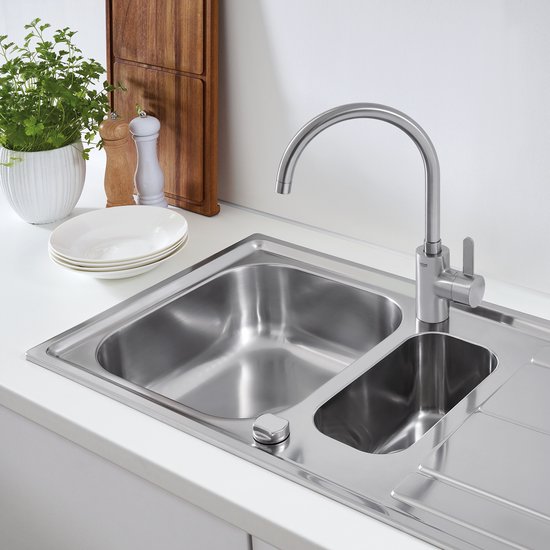 RVS Grohe kraan op een roestvrijstalen spoelbak in een keukenomgeving.