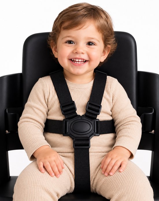 Lachend kind in een beige geribbelde outfit, vastgezet met een zwart 5-punts ZitZachtje harnas in een zwarte kinderstoel.