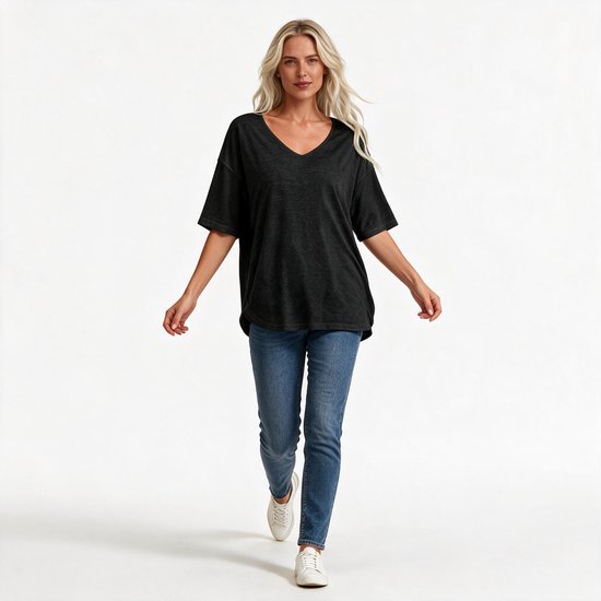 Blond model loopt in een zwart T-shirt met V-hals, halflange mouwen en blauwe jeans.