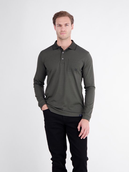 Man in een donkergroen poloshirt met lange mouwen, borstzak en zwarte broek.