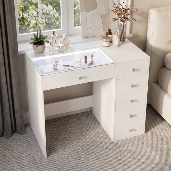 Witte kaptafel met verlicht glazen blad en uitgetrokken laden, ingericht met make-up.