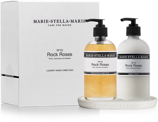 Een witte doos met de tekst 'MARIE-STELLA-MARIS', naast een doorzichtige pompflacon met gele zeep en een witte pompflacon met witte lotion. Beide flacons hebben een etiket met 'Rock Roses'.