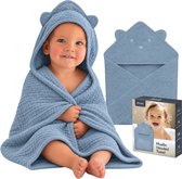 Baby in blauwe mousseline badcape met berenoren op de capuchon, naast de verpakking van de Lionelo Muslin Hooded Towel.