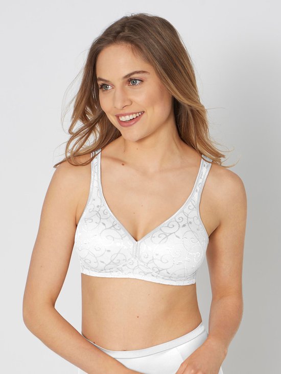 Model van voren gezien, draagt een witte beugelloze bh met een bloemenpatroon.